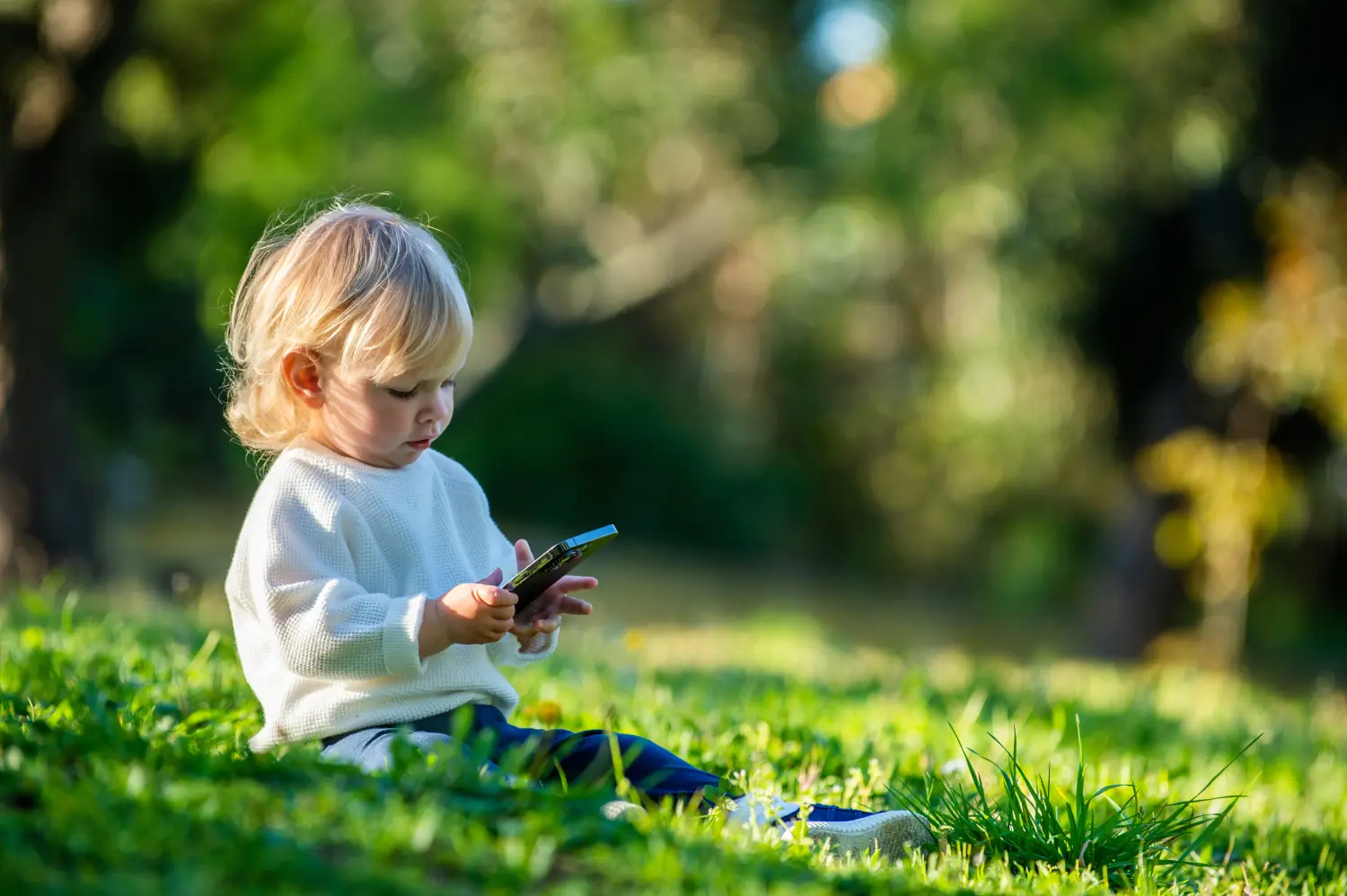 Kind mit Handy im Freien.